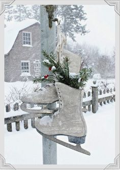 a pair of ice skates sitting on top of a pole in front of a house