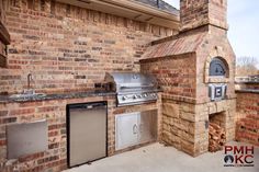 an outdoor kitchen with grill, sink and oven built into the side of a brick building