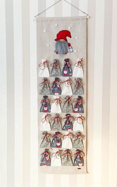 a christmas decoration hanging on the wall with santa's hat and stockings in it