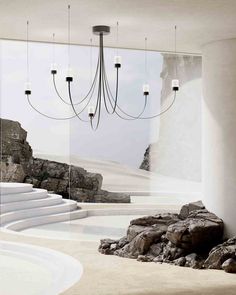 a room that has some rocks in the floor and a chandelier hanging from the ceiling