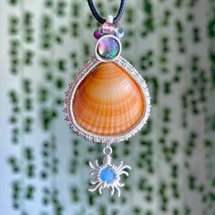 One of a kind, hand wire-wrapped pendant featuring an orange cockle shell (found off the fl shores), flashy abalone shell, mixed beads, & sun charm wrapped in plated silver. (Named after one of YOU.)💗 Free black necklace cord included; Made with love, as always.<3 Beach Wire Wrapped Shell, Bohemian Wire Wrapped Shell As Gift, Bohemian Wire Wrapped Shell Gift, Wire Wrapped Shell Gift, Handmade Spiritual Shell, Handmade Shell Pendant In Ocean-inspired Style, Handmade Silver Abalone Shell, Bohemian Abalone Shell For Gift, Handmade Ocean-inspired Abalone Shell