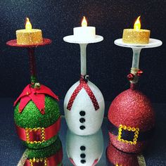 three christmas decorations with lit candles on them