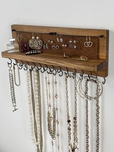 The Original All-in-One Wall-Mounted Jewelry Organizer - Handmade in the USA FEATURES: * Double row of staggered hooks - choice of Black, Silver or Gold * Cute and unique wires to hold dangle and hoop earrings * Cork panel holds stud earrings - backs stay on! * Easy to hang flush mount  * Woman-owned, minority-owned, and veteran-owned business Organize your necklaces, bracelets, and earrings with this beautiful, functional jewelry shelf! This handcrafted jewelry organizer adds a touch of charm t Wall Hanging Necklace Holder, Unique Jewelry Organizer, Diy Wood Jewelry Holder, Jewelry Organizer Crochet, Bracelet Storage Ideas, Jewlrey Organization Wall Diy, Cute Shelf Ideas, Western Jewelry Holder, Necklace Wall Display