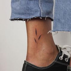 a woman's foot with a small tattoo on the side of her leg,