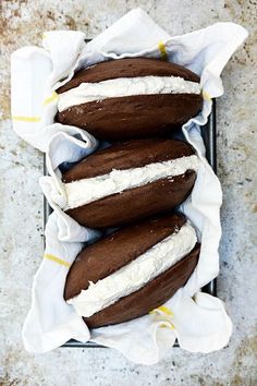 three chocolate donuts covered in white frosting