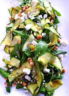 a white plate topped with cucumbers and other vegetables