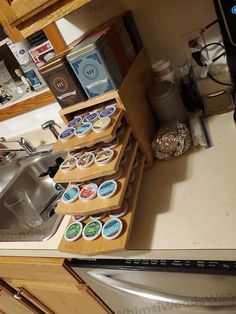 a kitchen counter with several trays of cupcakes next to a sink and dishwasher