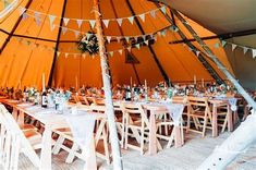 the inside of a tent with tables and chairs