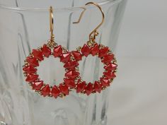 Unusual red and silver seed bead hoop earrings. The soft red color of the diamond shaped beads is set off by the tiny silver beads. The beads are woven into a simple hoop pattern. The earrings are 2 inches long and 1 inch wide on handmade ear wires. Red Teardrop Jewelry With Tiny Beads, Red Hoop Earrings With Tiny Beads, Red Beaded Small Hoop Earrings, Red Faceted Beads Round Earrings, Beaded Hoop Earrings, Beaded Hoops, Silver Beads, Diamond Shapes, Seed Beads