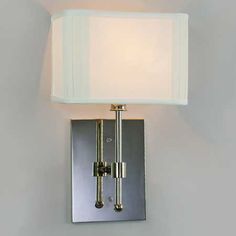 a wall mounted light with a white shade on the top and bottom part of it