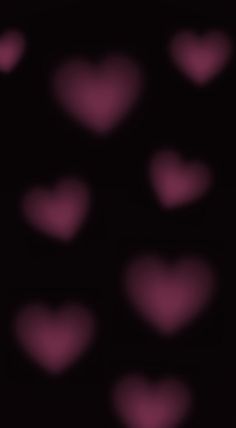 many pink hearts on a black background