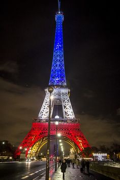 the eiffel tower lit up in red, white and blue