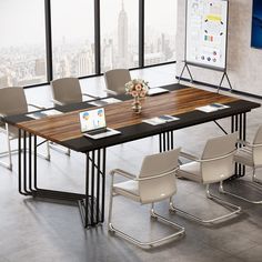 a conference table with chairs around it and a laptop computer on the desk next to it