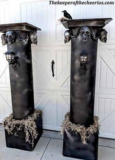 two tall black vases sitting next to each other in front of a garage door