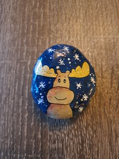 a painted rock sitting on top of a wooden table