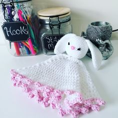 a crocheted bunny is sitting on the counter next to some pens and markers