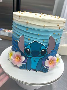 a blue and white cake with an image of stitching lillies on the side