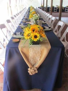 the table is set with sunflowers and place settings