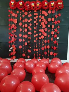 some red balloons are in front of a black wall with stars and owls on it