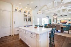 a large kitchen with an island in the middle and chairs at the table on either side