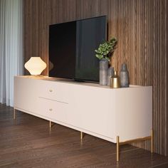 an entertainment center with a flat screen tv and vases on the top shelf, in front of a wood paneled wall