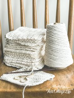 some yarn and scissors on a wooden chair