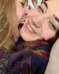 two women laying next to each other smiling