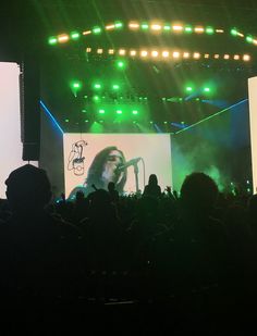 a concert scene with the stage lit up and people in the audience looking at it