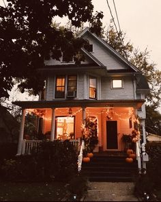 a house decorated for halloween with pumpkins and lights