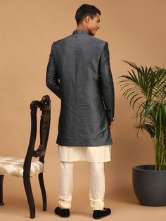 VASTRAMAY Men's Grey Indo Western Combo Set Look dapper in this stylish grey Indo Western combo set from VASTRAMAY. Perfect for any festive occasion or special event, this set includes a cream colored kurta, a grey angrakha jacket, and a comfortable churidar. Key Features: Cream colored solid straight knee-length kurta with a mandarin collar, long sleeves, button placket, and straight hem. Grey angrakha style above-knee-length ethnic jacket with a mandarin collar, long sleeves, full button plack Fitted Gray Set For Festive Occasions, Festive Fitted Gray Set, Fitted Gray Sets For Festive Occasions, Festive Gray Long Sleeve Sets, Gray Long Sleeve Wedding Set, Fitted Gray Sets For Eid, Gray Fitted Kurta For Eid, Fitted Gray Kurta For Eid, Festive Long Sleeve Gray Kurta