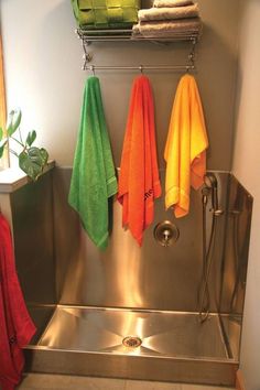 towels are hanging on the rack in front of an open shower door and next to a towel rack