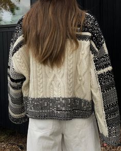 the back of a woman's sweater that has been knitted in different colors