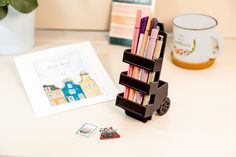 a stack of books sitting on top of a table next to a potted plant