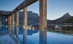 an empty swimming pool with mountains in the background and blue skies above it at dusk