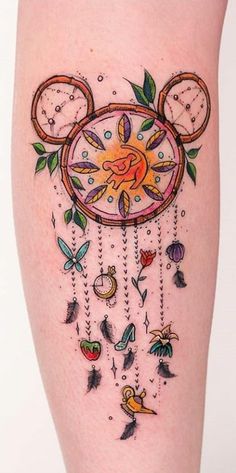 a woman's leg with tattoos on it and an image of a clock in the shape of a mouse