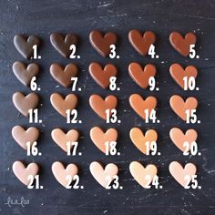 chocolate hearts arranged in the shape of numbers on a black surface with white writing that reads 1, 2, 3, 4, 5, 6, and 7