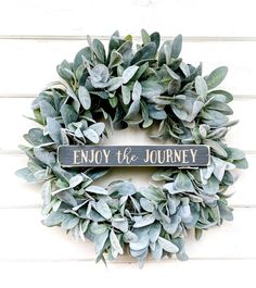 a wreath with the words enjoy the journey on it and some green leaves around it