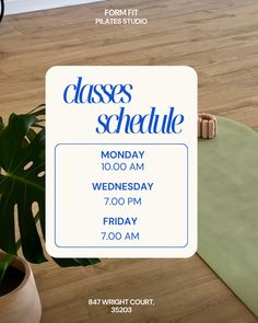 a class schedule is shown on the floor next to a potted plant and an empty mat