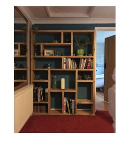 a bookshelf filled with lots of books next to a white vase and door