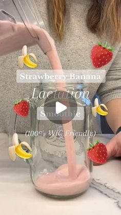 a woman pouring strawberries and bananas into a mason jar with pink liquid in it