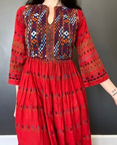 1970s Afghan dress. *Red floral printet cotton fabric  *Embroidered yoke. *The dress is unlined. *Zipper down the back. *Used vintage condition. Has a small stain on the skirt (see picture) and some darker discoloration on the front near the waistline (see picture) Such a beautiful dress but shows signs of age and wear. ERA: 1970s or earlier LABEL: None. Made in Pakistan SIZE: XS  (Please check measurements) FABRIC: Cotton Measurements are taken flat and must be doubled: Chest: 43 cm x 2 Waist: Traditional Red Fall Dresses, Red Folk Style Floral Print Dress, Red Folk Dress With Floral Print, Folk Style Cotton Floral Print Dress, Folk Style Cotton Dress With Floral Print, Retro Embroidered Cotton Dress, Red Fitted Folk Embroidered Dress, Vintage Floral Embroidered Dress For Fall, Retro Cotton Dresses For Festival