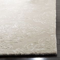 a large white rug on top of a wooden floor