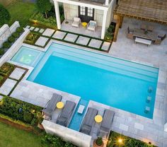 an aerial view of a swimming pool with lounge chairs and lights around the pools edge