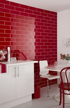 a red brick wall in a kitchen with white table and chairs next to the counter