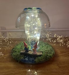 a glass jar with fairy lights in it sitting on top of a wooden table