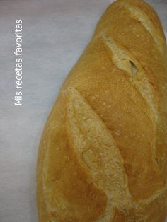 a close up of a loaf of bread on a white tablecloth with the end cut off