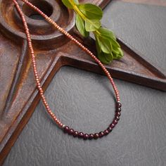 This is a dainty beaded necklace in a combination of small dark red garnet stones and tiny peach pink seed beads with a subtle shimmery finish. The stones are separated from the glass beads by small solid sterling silver etched Hill Tribe beads. The necklace is finished with a solid sterling silver spring ring clasp. You can add an optional silver plated 2-inch extender chain for added versatility or peace of mind if this is a gift. This modern necklace gives you a fun pop of color. It's lightweight and the optional extender chain would make it easy to layer with some other faves. Necklace length: 16 inches; optional 2" extender chain available Your necklace will arrive in an eco-friendly Kraft paper gift box. Beaded Necklace Collection: https://www.etsy.com/shop/BonArtsStudio?ref=seller-p Handmade Burgundy Necklaces With Round Beads, Rose Gold Necklaces With Round Tiny Beads, Burgundy Beaded Necklaces With Round Beads As Gift, Amber Beaded Necklaces With Spacer Beads As Gift, Handmade Burgundy Beaded Necklaces As Gift, Handmade Burgundy Beaded Necklaces For Gifts, Layering Jewelry, Modern Necklace, Necklace Collection