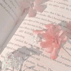 an open book with pink flowers on it