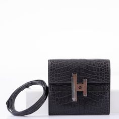 The Cinhetic design, which draws inspiration from moving Kinetic art, is rendered here as a square wallet surrounding an ingenious closure. When locked, the clasp resembles an H for Hermes, but when open, the pieces rotate into a sleek metal line. This extraordinary example is done in Matte Graphite Alligator with Palladium hardware, and features the super useful removable matching Alligator shoulder strap, and a small leather-bound mirror which fits perfectly into one of the wallet’s interior s High-end Formal Rectangular Wallet, Designer Crocodile Pattern Wallet, Luxury Wallet With Crocodile Pattern, Luxury Crocodile Pattern Business Wallets, Designer Crocodile Pattern Rectangular Wallet, Luxury Crocodile Pattern Wallet For Business, Luxury Crocodile Pattern Wallets For Business, Luxury Wallets With Crocodile Pattern For Business, Luxury Business Wallets With Crocodile Pattern