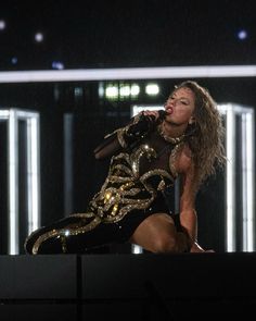 a woman in gold and black outfit on stage